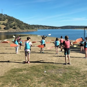 Grupo de alumnos en la orilla del lago preparándose para realizar actividades acuáticas en el programa English Town.
