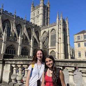 Dos estudiantes de InterWay sonriendo frente a una imponente catedral europea en su experiencia cultural del programa English Week.