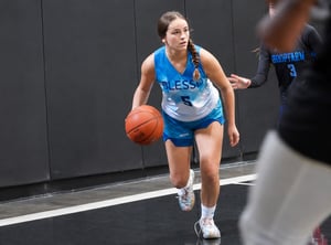 Primer plano en acción de una joven jugadora concentrada y botando el balón durante un entrenamiento intensivo en el extranjero, reflejando el enfoque, la madurez y la inmersión lingüística y deportiva que fomenta el International Basketball Camp de InterWay.