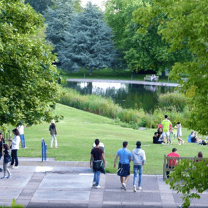 Estudiantes del curso de idiomas de InterWay paseando y relajándose en las amplias zonas verdes y ajardinadas junto al lago del campus en Bath.