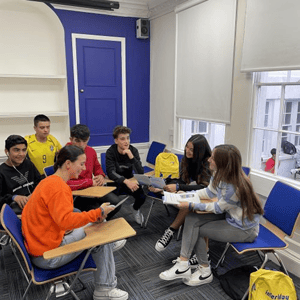 Estudiantes del programa de idiomas de InterWay reunidos en grupos y debatiendo durante una clase interactiva de inglés en la escuela de Bath.