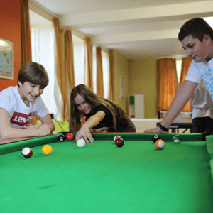 Estudiantes del curso de inglés de InterWay divirtiéndose y jugando al billar en la sala de juegos de la residencia