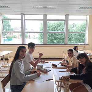 Estudiantes internacionales de InterWay sonriendo en un aula luminosa durante sus clases de inglés en el centro residencial