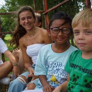 Tres niños pequeños conversando y compartiendo momentos de juego al aire libre en el campamento de verano de InterWay.