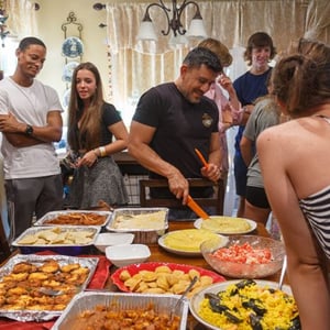 Estudiantes del curso de idiomas de InterWay compartiendo una cena buffet en una sala interior durante una reunión grupal en Estados Unidos.