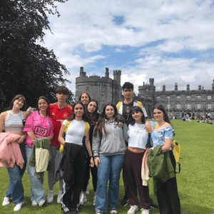 Grupo de estudiantes de los cursos de inglés de InterWay posando juntos en los jardines del Castillo de Kilkenny en Irlanda durante una excursión de verano.