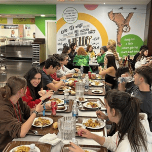 Alumnos del programa internacional de InterWay compartiendo mesa y almorzando juntos en el comedor o cafetería del campus residencial.