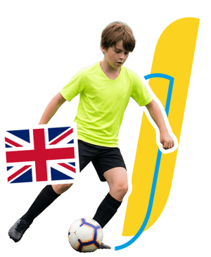 joven futbolista con camiseta amarilla conduciendo un balón durante el curso de fútbol en Londres de InterWay, junto a la bandera del Reino Unido
