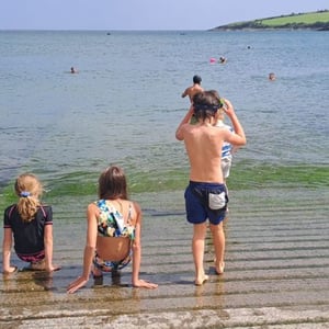 Tres estudiantes del campus de idiomas de InterWay disfrutando de una jornada de playa en la costa de Irlanda.