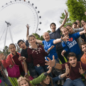 Estudiantes del curso de inglés en la University of Greenwich de InterWay posando con los brazos en alto bajo la estructura del London Eye.