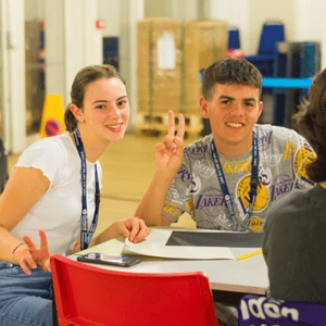 Una alumna y un alumno del curso de InterWay en la University of Greenwich sentados en un aula moderna compartiendo apuntes con una sonrisa.