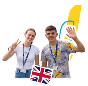 Dos estudiantes sonriendo y saludando con las acreditaciones del curso en Londres de InterWay, junto a la bandera del Reino Unido.