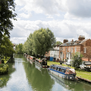 Canal tradicional rodeado de vegetación con barcas alargadas amarradas en Oxford, una de las visitas culturales del programa de idiomas de InterWay.