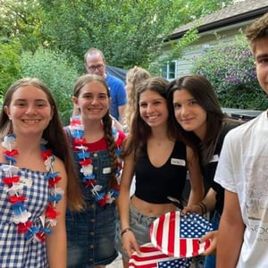 Cuatro estudiantes del viaje de idiomas de InterWay vestidas con collares y complementos con la bandera estadounidense celebrando el 4 de julio en EE. UU.