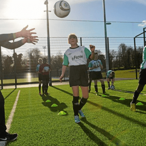 Una jugadora del programa de fútbol e idiomas de InterWay en Irlanda sigue con la mirada un balón en el aire durante una sesión de entrenamiento técnica.