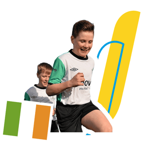 Dos niños corriendo y sonriendo durante el Soccer Camp en Irlanda de InterWay, junto a la bandera irlandesa