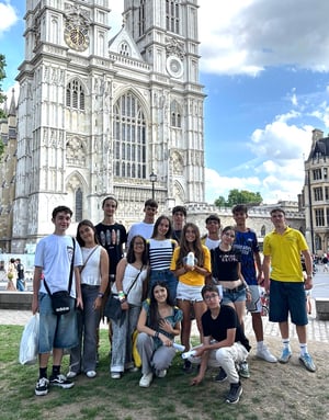 Un grupo de estudiantes del curso de inglés de InterWay posa sonriente frente a la imponente fachada gótica de la Abadía de Westminster durante una excursión a Londres.