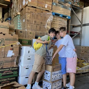 Alumnos de InterWay colaborando en un almacén comunitario de Estados Unidos mediante la carga y organización de cajas para donaciones.