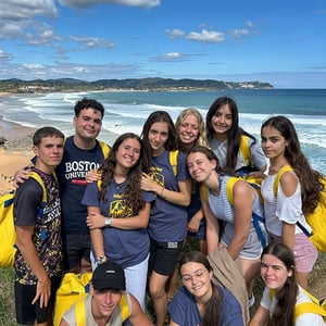 Grupo de estudiantes de Interway posando juntos en un mirador frente a la playa durante un viaje de idiomas