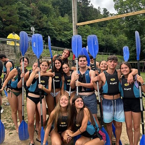 Estudiantes de Interway equipados con chalecos salvavidas y remos listos para una actividad acuática de kayak