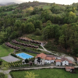 Vista aérea de las instalaciones y cabañas rodeadas de naturaleza de un campamento de verano de Interway