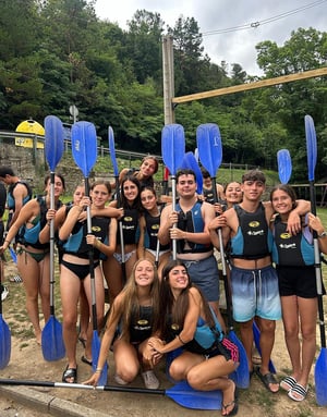 Jóvenes de Interway con chalecos de seguridad y remos de kayak posando juntos antes de comenzar su actividad deportiva