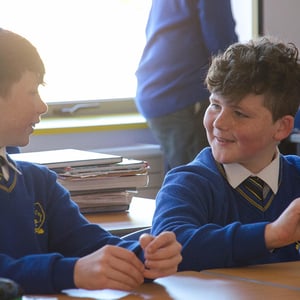Alumnos de Interway vistiendo el uniforme escolar azul mientras conversan en el aula de un colegio irlandés