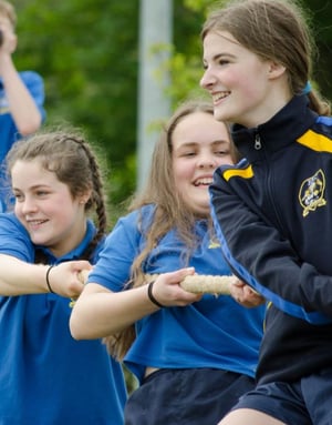 Alumnas de Interway sonriendo mientras compiten en un juego de arrastre al aire libre en Irlanda