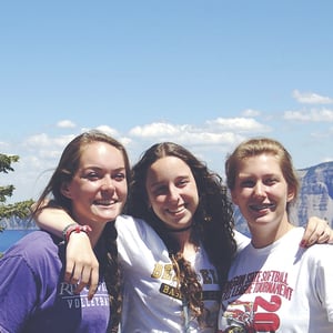Tres alumnas de Interway compartiendo un momento de amistad en un campus universitario o escolar de Estados Unidos